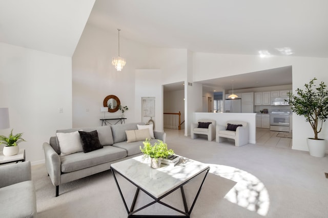 living room featuring a notable chandelier, light colored carpet, high vaulted ceiling, and baseboards