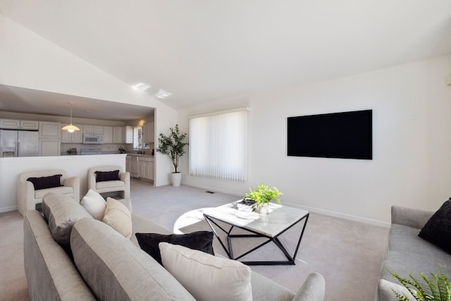 living room with vaulted ceiling, light colored carpet, and baseboards