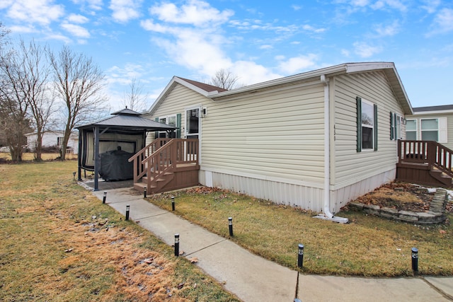 view of side of property with a yard and a gazebo