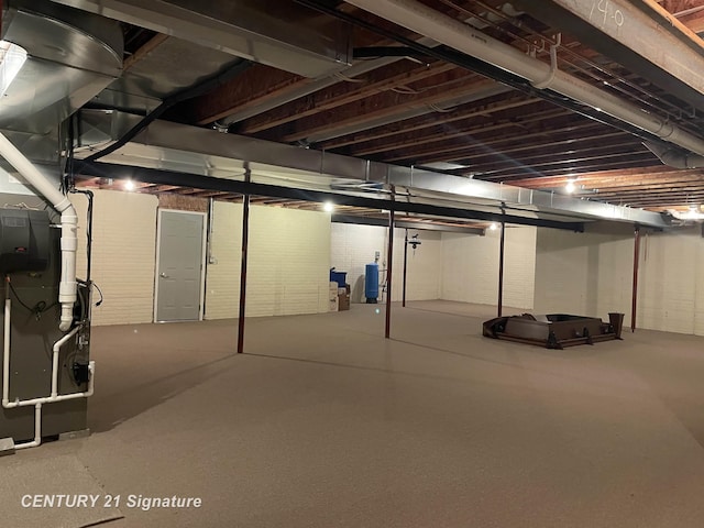 unfinished below grade area featuring water heater and heating unit