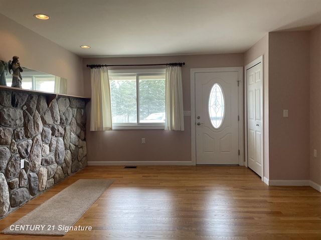 foyer featuring baseboards, wood finished floors, visible vents, and recessed lighting