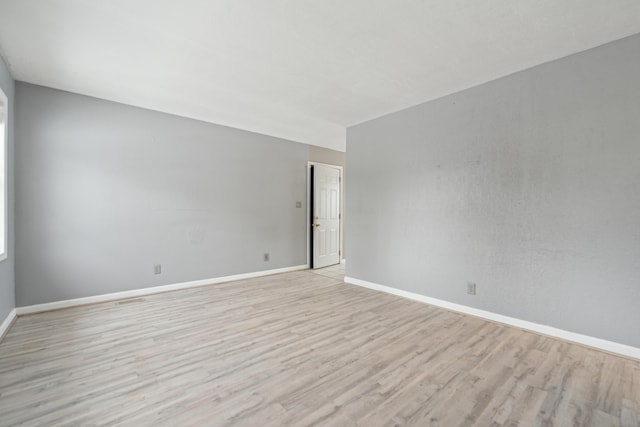 unfurnished room featuring light wood finished floors and baseboards