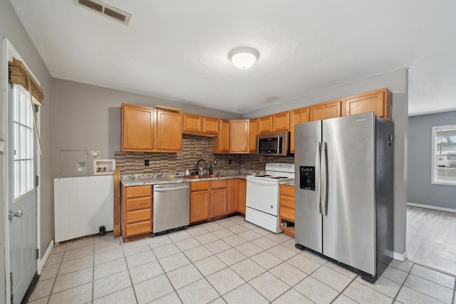 kitchen with light countertops, visible vents, backsplash, appliances with stainless steel finishes, and light tile patterned flooring