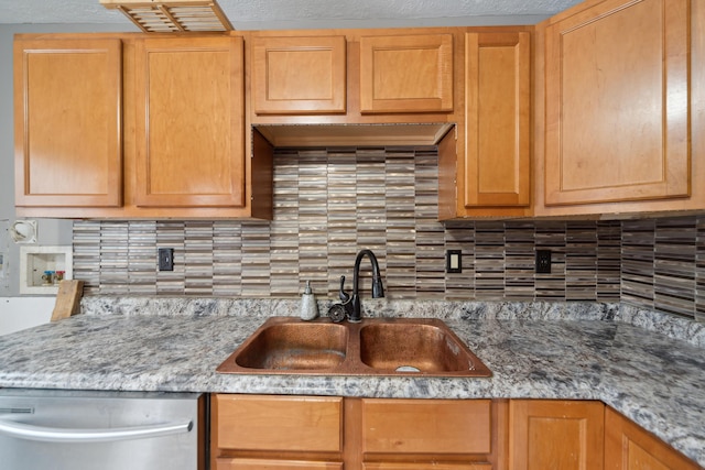 kitchen featuring stainless steel dishwasher, decorative backsplash, and a sink