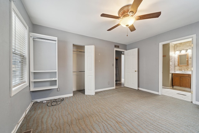 unfurnished bedroom featuring baseboards, a closet, visible vents, and light colored carpet