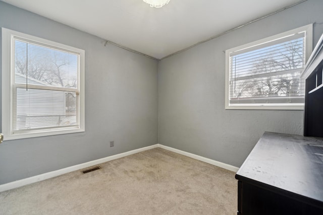 interior space with carpet flooring, visible vents, and baseboards