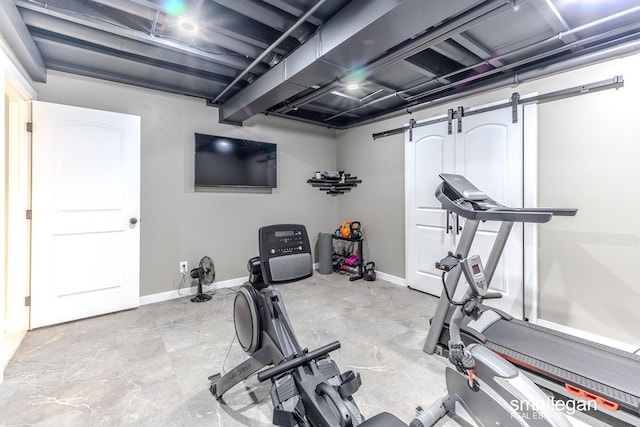 workout area featuring a barn door and baseboards