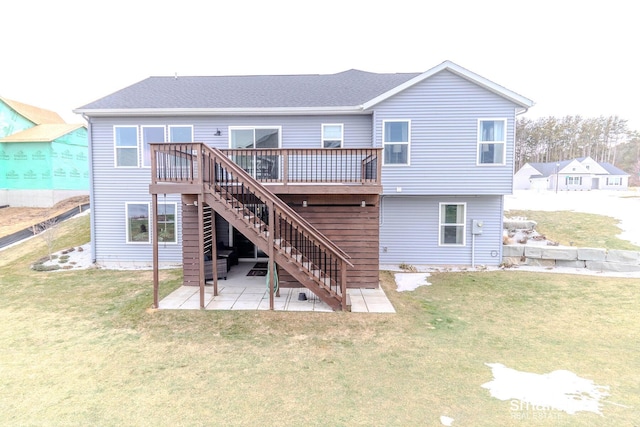 rear view of property featuring a yard, a patio, a shingled roof, stairway, and a wooden deck