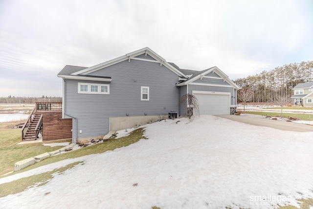 exterior space with driveway, a garage, and stairs