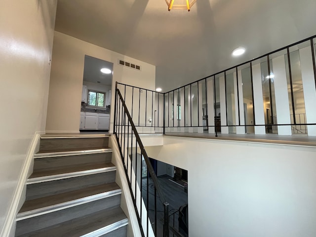 staircase with visible vents and recessed lighting