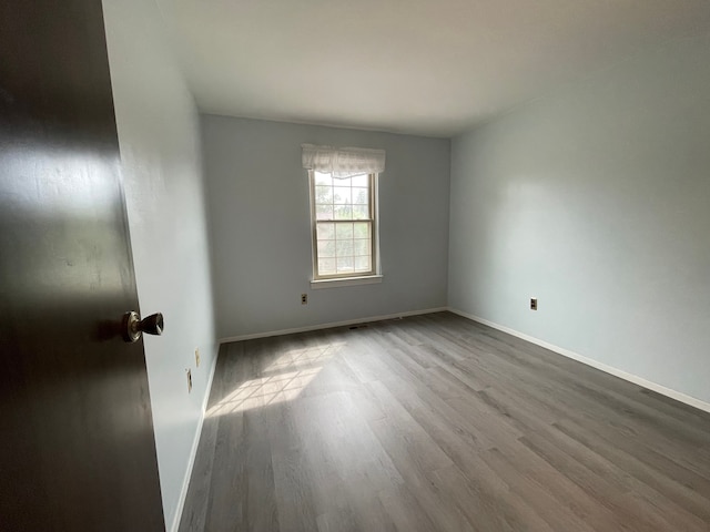 empty room with wood finished floors and baseboards