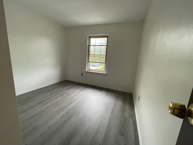 unfurnished room featuring baseboards and wood finished floors