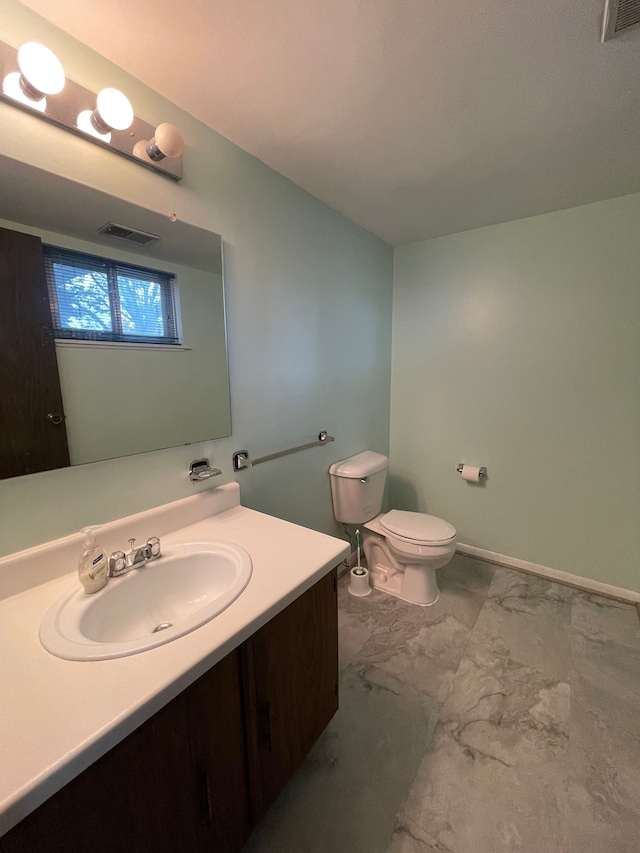 bathroom featuring marble finish floor, visible vents, vanity, and toilet