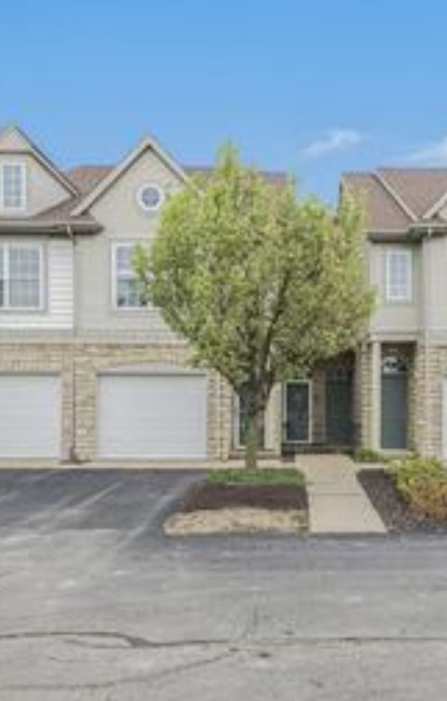 view of property with a garage and driveway