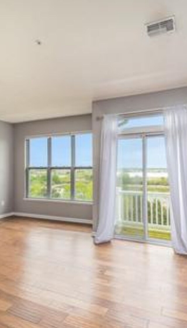 spare room featuring visible vents and wood finished floors