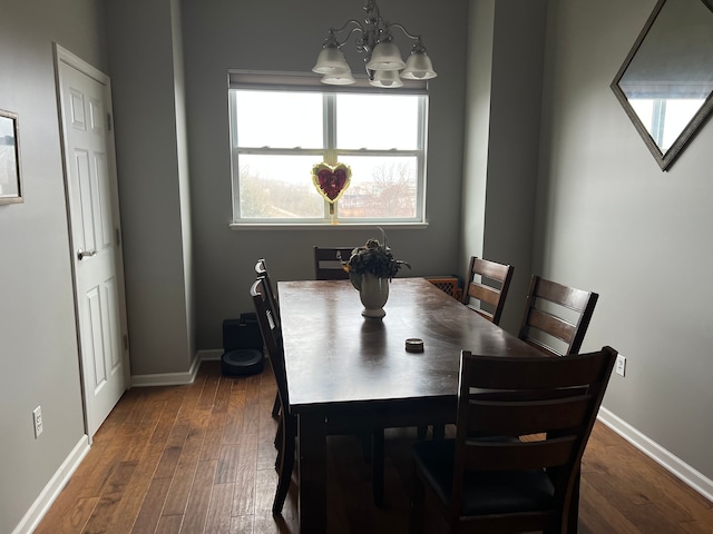 dining room with dark wood-style floors, plenty of natural light, baseboards, and an inviting chandelier