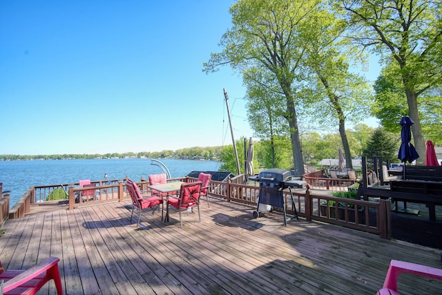 wooden terrace with a water view and grilling area