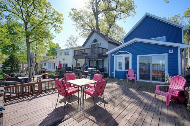 deck with outdoor dining space and area for grilling