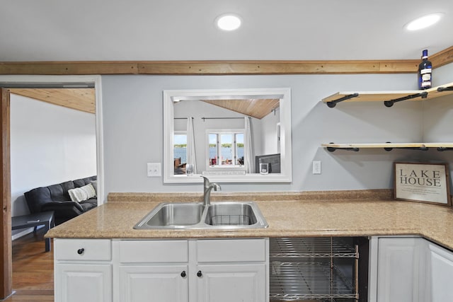 kitchen featuring beverage cooler, a sink, white cabinetry, vaulted ceiling, and open shelves