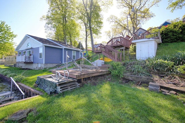 view of yard featuring stairs, an outbuilding, a deck, and a storage unit