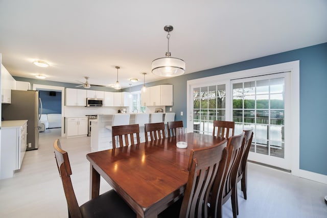 dining room featuring light wood-style flooring and baseboards