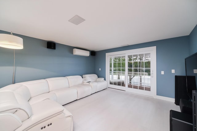 living room featuring a wall unit AC, baseboards, and wood finished floors