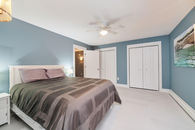 bedroom with a baseboard radiator, baseboards, ceiling fan, and multiple closets