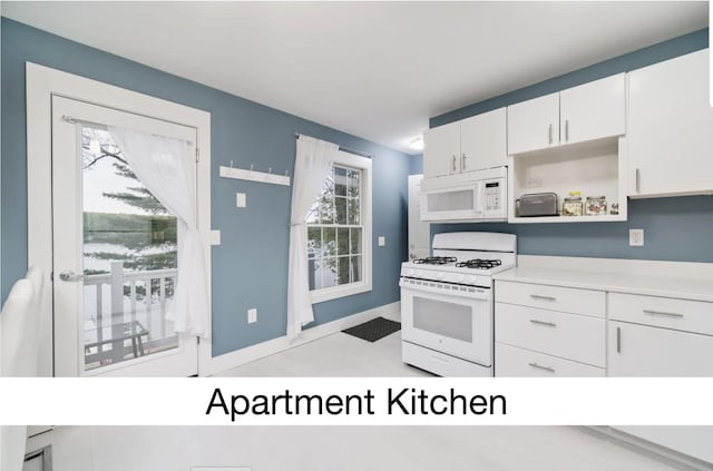 kitchen with light countertops, white appliances, a healthy amount of sunlight, and white cabinets