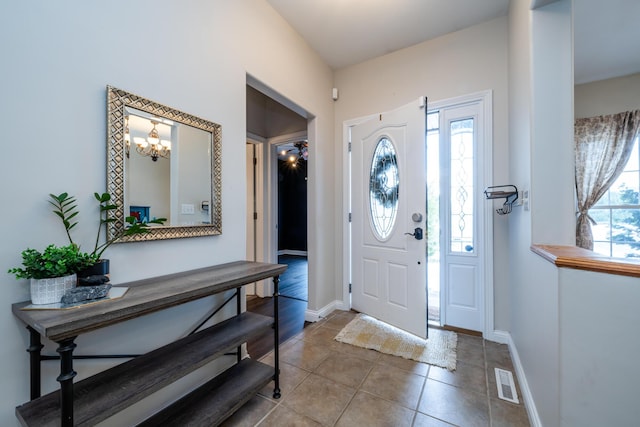 foyer entrance featuring baseboards, visible vents, and tile patterned floors