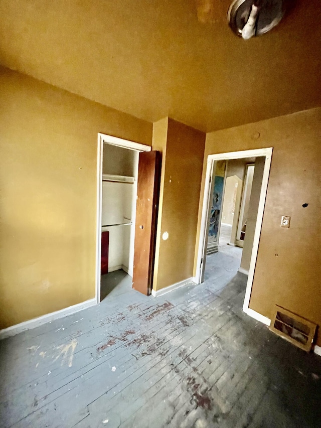 unfurnished bedroom featuring a closet, visible vents, and baseboards