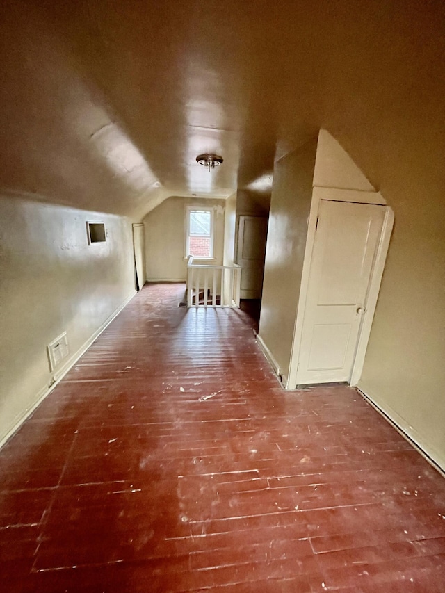 additional living space featuring vaulted ceiling and wood finished floors