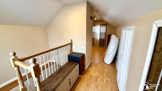 interior space with lofted ceiling, baseboards, visible vents, and light wood-style floors