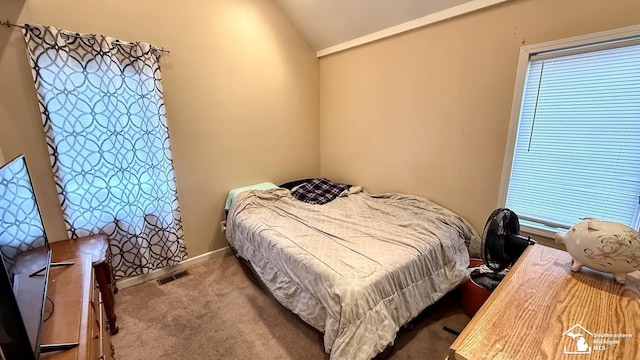 carpeted bedroom featuring lofted ceiling, visible vents, and baseboards