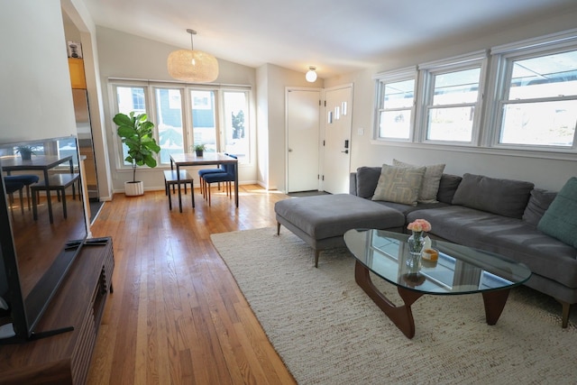 living room with lofted ceiling, plenty of natural light, and light wood-type flooring