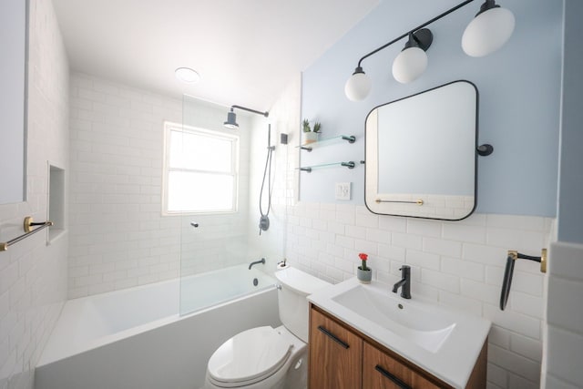 full bath featuring toilet, shower / washtub combination, vanity, and tile walls