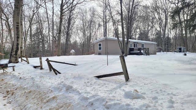 yard layered in snow featuring a wooden deck