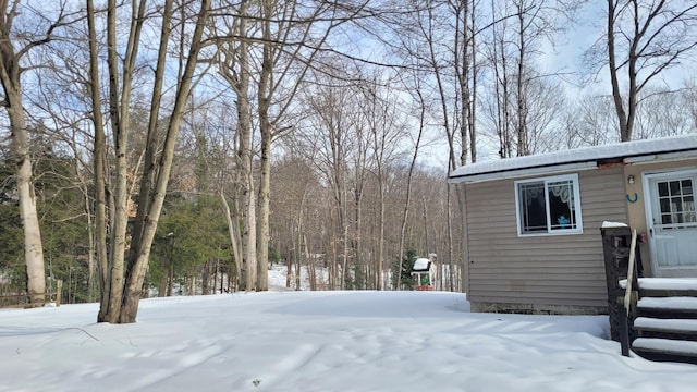 yard covered in snow featuring an outbuilding