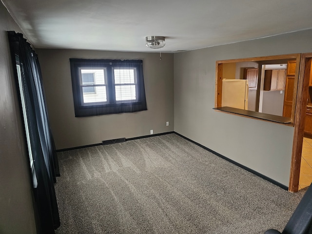 empty room featuring visible vents, baseboards, and carpet flooring