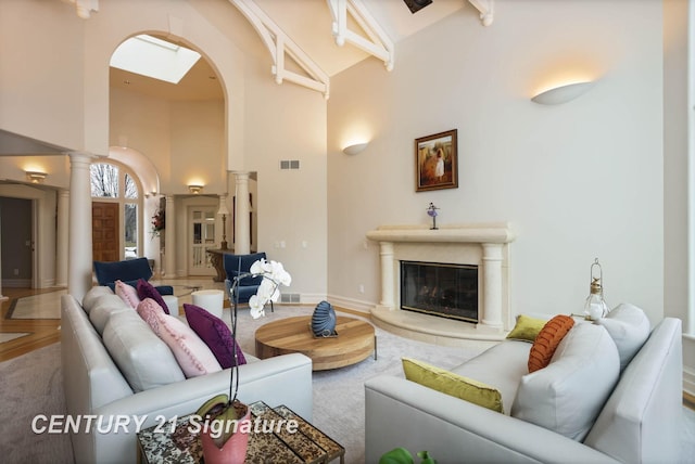 living room featuring visible vents, ornate columns, a fireplace, high vaulted ceiling, and beam ceiling