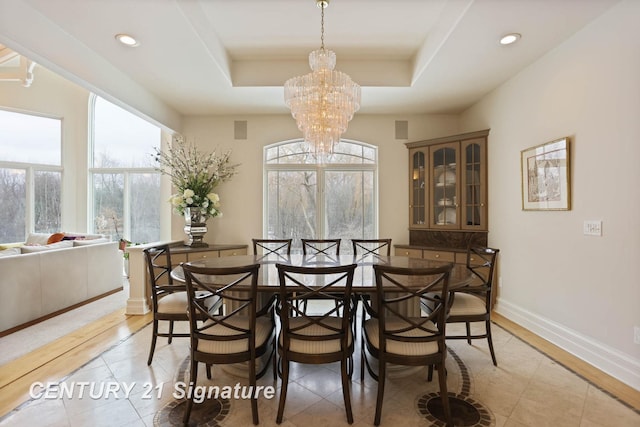 dining space with a chandelier, a tray ceiling, recessed lighting, and baseboards