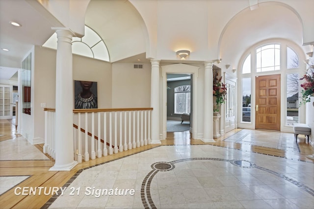 foyer with ornate columns, recessed lighting, plenty of natural light, and baseboards