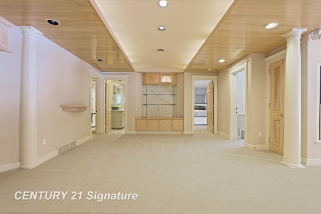 empty room with decorative columns, visible vents, light colored carpet, wooden ceiling, and recessed lighting