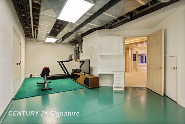 workout area with concrete block wall and electric panel