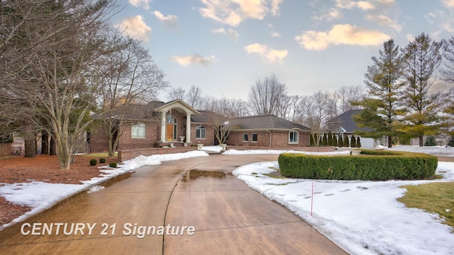 view of front of property featuring concrete driveway and brick siding