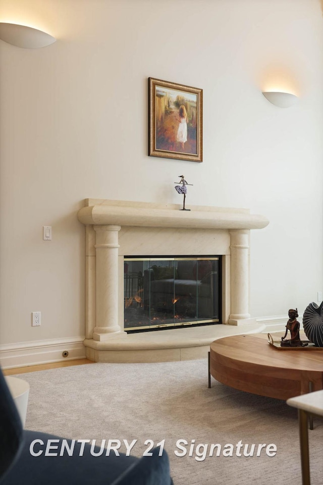 carpeted living room with a glass covered fireplace