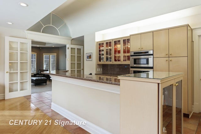 kitchen featuring light wood-style flooring, glass insert cabinets, french doors, double oven, and recessed lighting