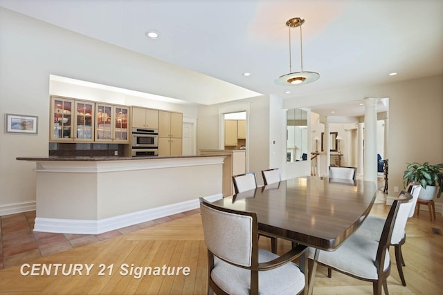 dining room with baseboards, recessed lighting, and ornate columns