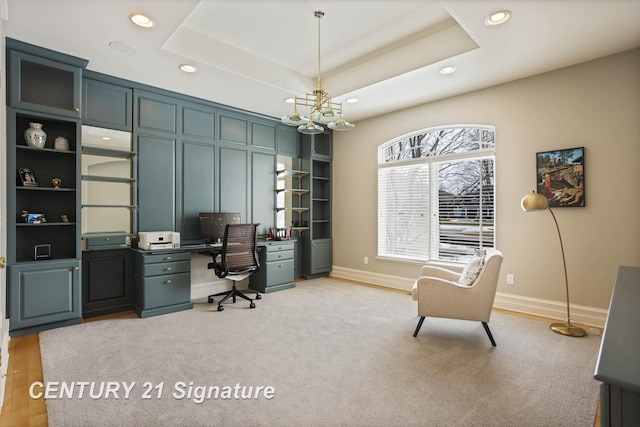 home office with built in shelves, baseboards, a raised ceiling, and recessed lighting