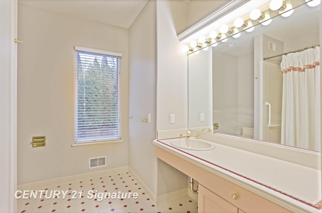 bathroom with curtained shower, baseboards, visible vents, and vanity