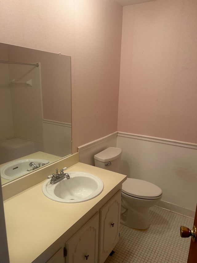 bathroom featuring toilet, vanity, walk in shower, and tile patterned floors